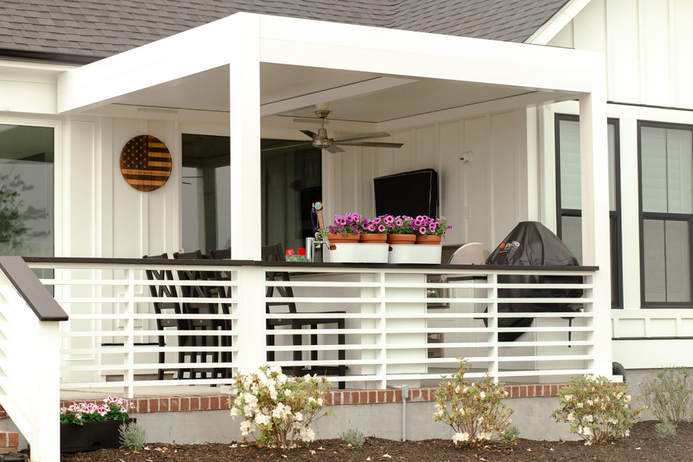 Modelo de terraza planta baja tradicional pequeña en patio trasero con cocina exterior, pérgola y barandilla de metal