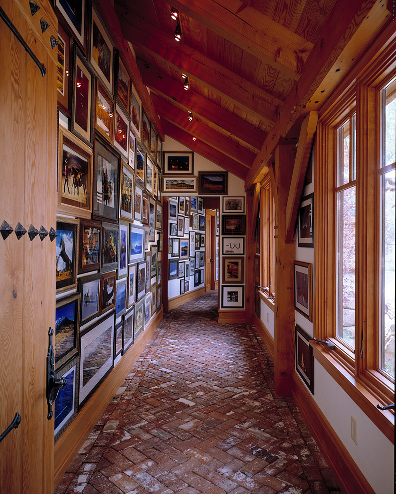 This is an example of a country hallway in Boston with white walls and brick floors.