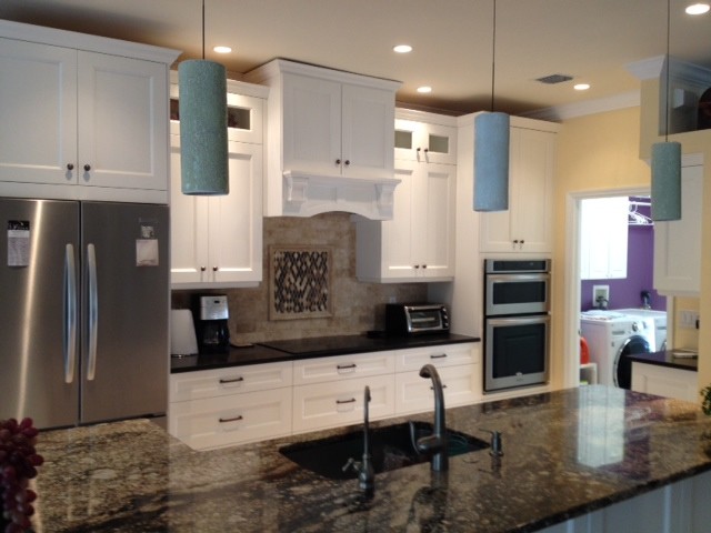 Mid-sized transitional travertine floor open concept kitchen photo with an undermount sink, shaker cabinets, white cabinets, granite countertops, beige backsplash, stone tile backsplash, stainless steel appliances and an island