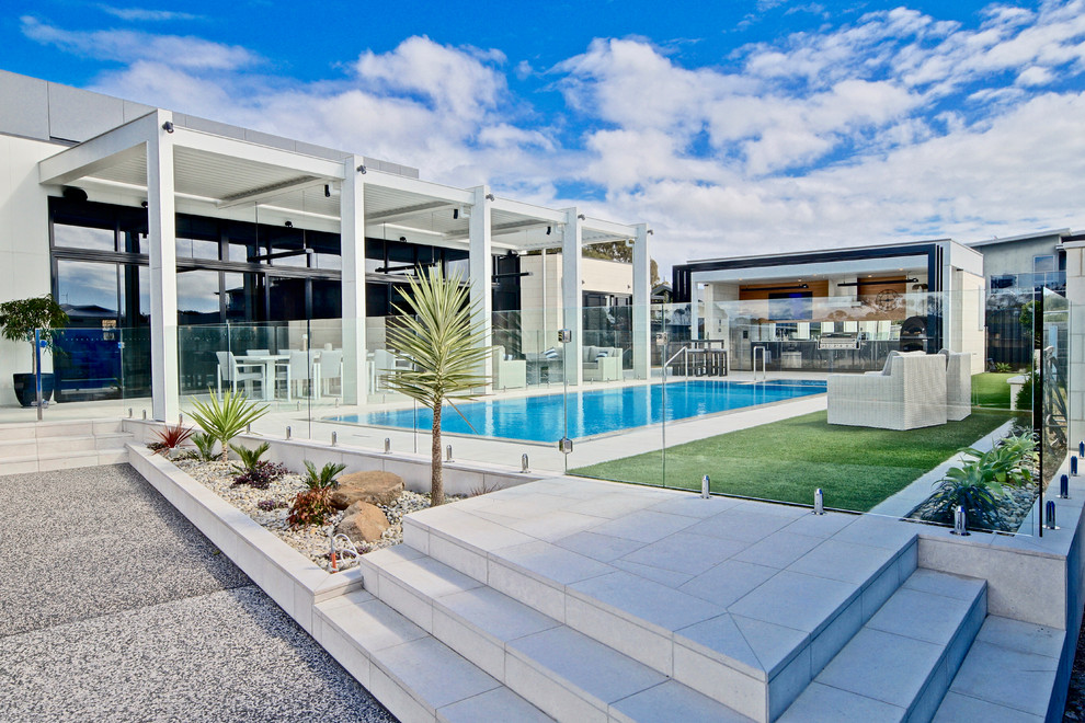 Photo of a contemporary rectangular lap pool in Other with a pool house.