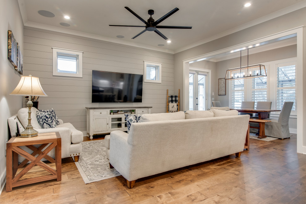 Immagine di un soggiorno tradizionale di medie dimensioni e aperto con pavimento in legno massello medio, TV a parete, pavimento marrone e pareti in perlinato