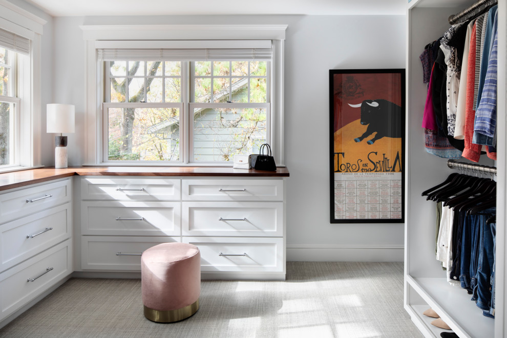 This is an example of a mid-sized transitional women's walk-in wardrobe in Boston with white cabinets, carpet, grey floor and shaker cabinets.