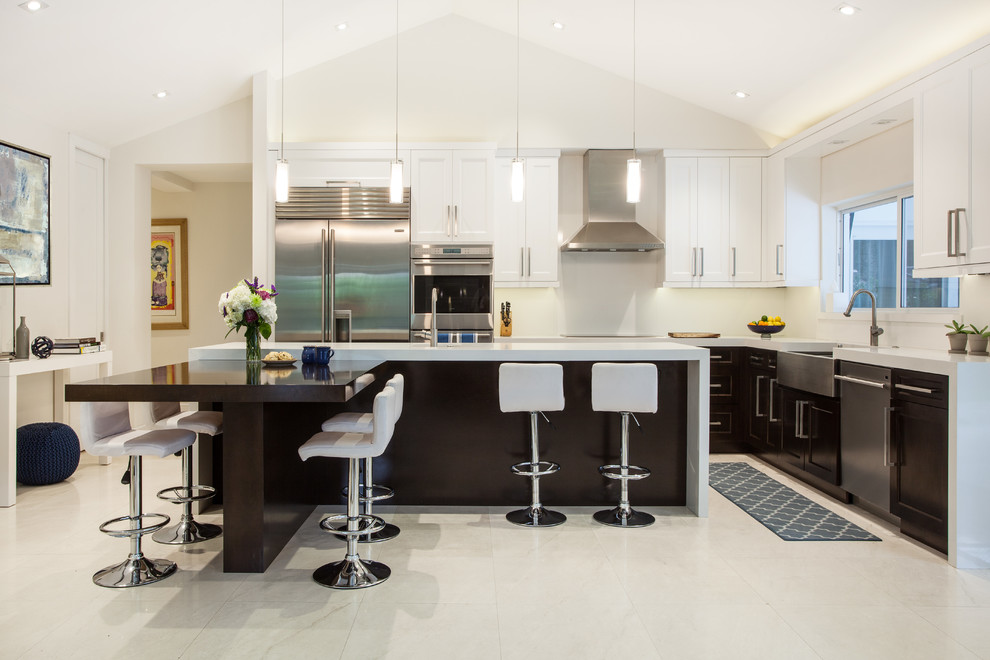 Inspiration for a large contemporary l-shaped open plan kitchen in Miami with a farmhouse sink, shaker cabinets, dark wood cabinets, quartz benchtops, white splashback, stainless steel appliances, marble floors and with island.