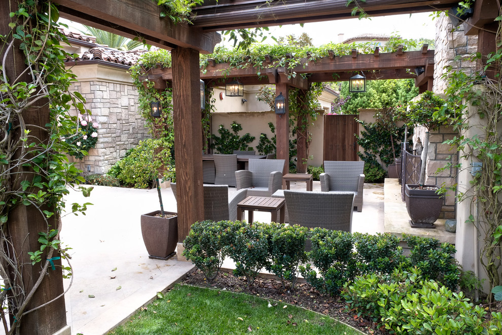Photo of a mid-sized mediterranean courtyard patio in San Diego with a fire feature, concrete slab and a pergola.