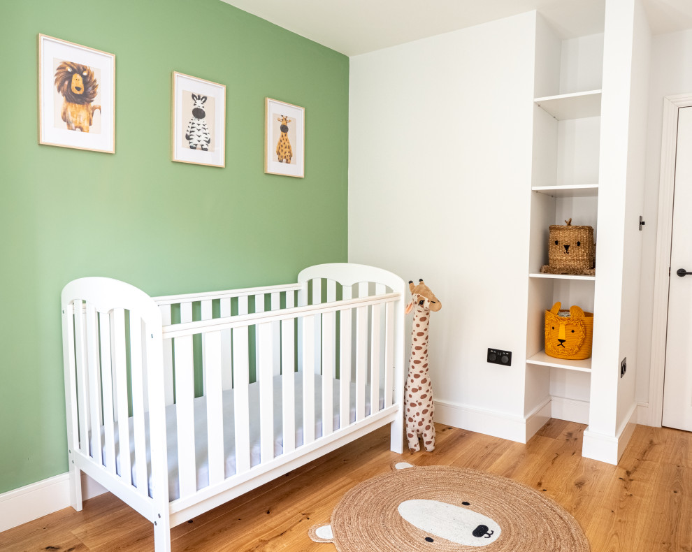 Inspiration for a medium sized victorian gender neutral nursery in London with green walls.