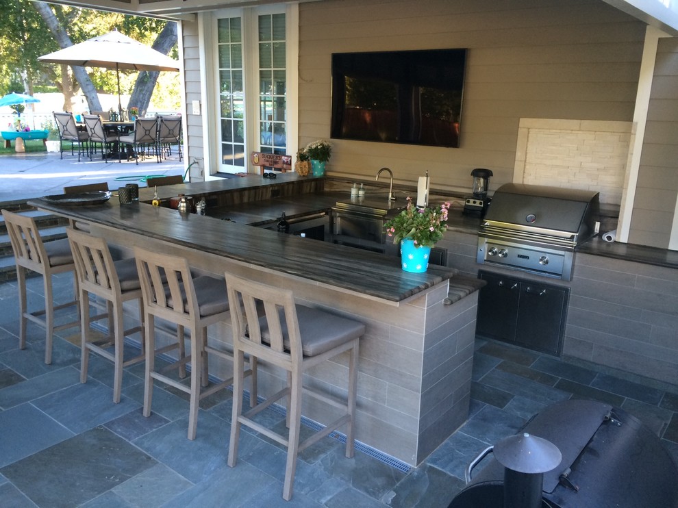 Patio kitchen - large traditional backyard tile patio kitchen idea with a roof extension