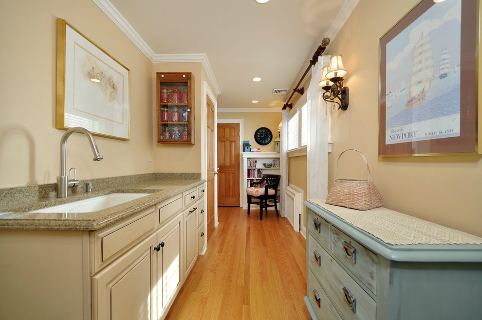 Inspiration for a large country galley utility room in New York with an undermount sink, raised-panel cabinets, beige cabinets, granite benchtops, beige walls, medium hardwood floors, a side-by-side washer and dryer, brown floor, grey splashback, shiplap splashback and planked wall panelling.