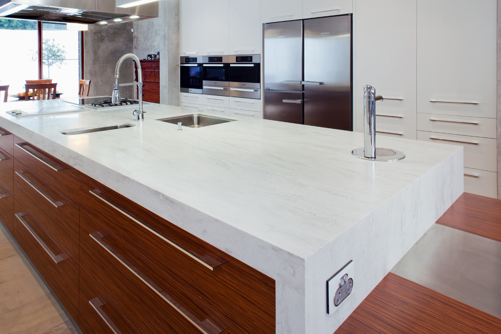 Design ideas for a large modern kitchen in Perth with an undermount sink, flat-panel cabinets, solid surface benchtops, stainless steel appliances, with island, medium wood cabinets and grey benchtop.