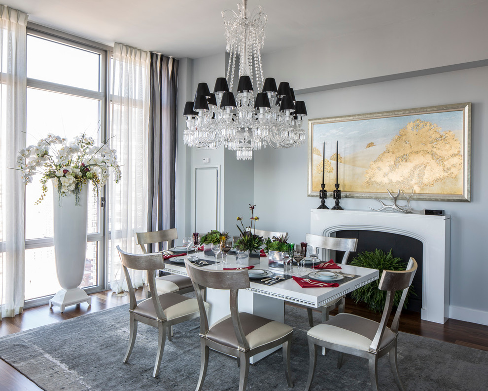 Mid-sized transitional open plan dining in New York with grey walls, medium hardwood floors, a standard fireplace and a plaster fireplace surround.