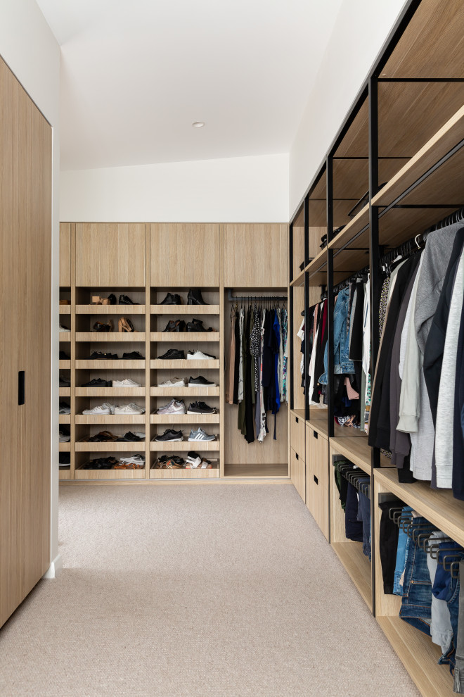Inspiration for a large retro gender neutral walk-in wardrobe in Sydney with flat-panel cabinets, light wood cabinets, carpet and beige floors.