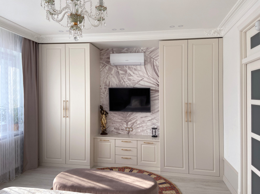 Идея дизайна: большая хозяйская спальня в стиле неоклассика (современная классика) с белыми стенами, полом из ламината, бежевым полом, обоями на стенах и телевизором