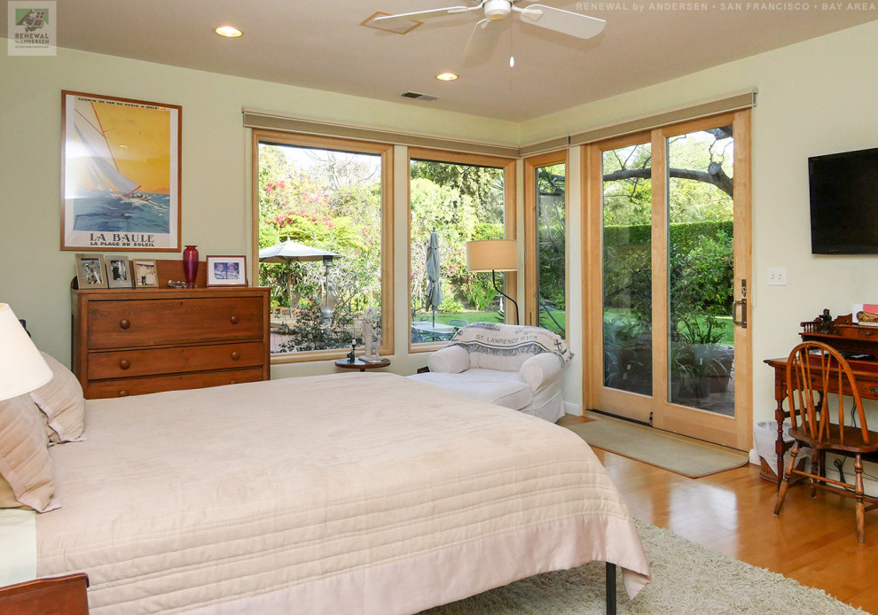 Mid-sized bedroom in San Francisco with yellow walls, light hardwood floors and no fireplace.