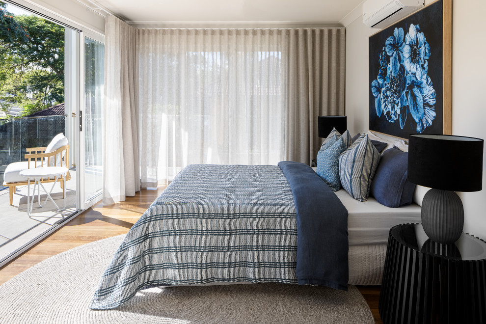 Modernes Gästezimmer ohne Kamin mit weißer Wandfarbe, braunem Holzboden und braunem Boden in Brisbane