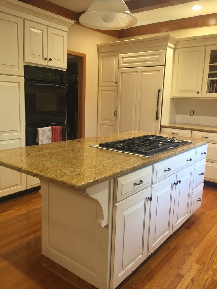 This is an example of a mid-sized modern u-shaped eat-in kitchen in Other with raised-panel cabinets, white cabinets and with island.