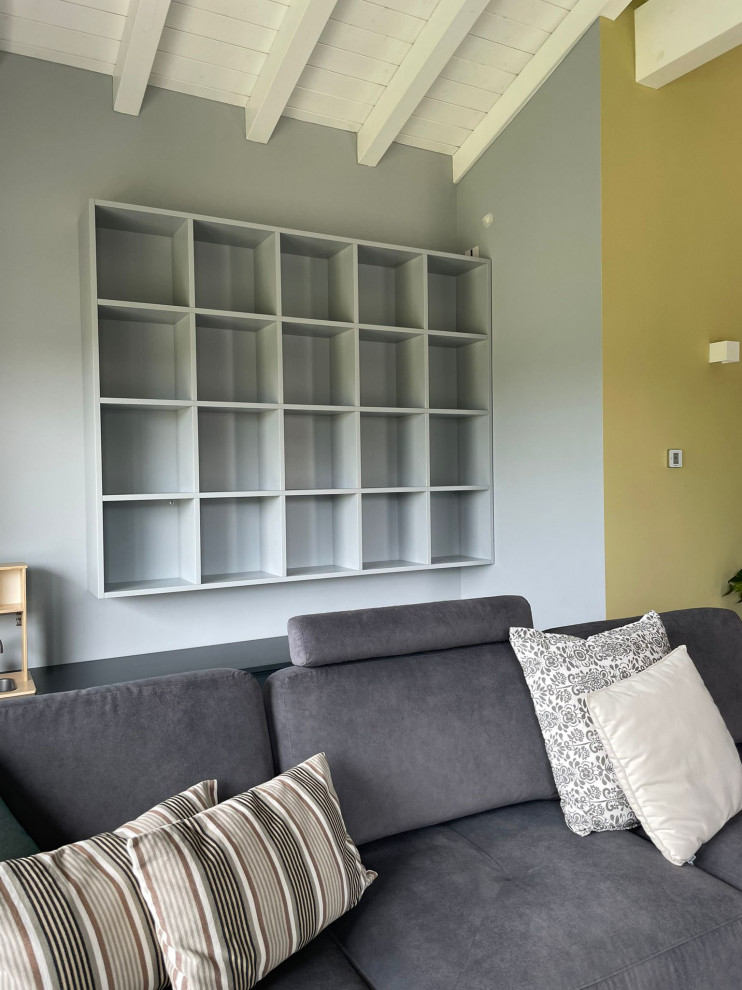 Immagine di un piccolo soggiorno minimalista con libreria, pareti blu e pavimento grigio