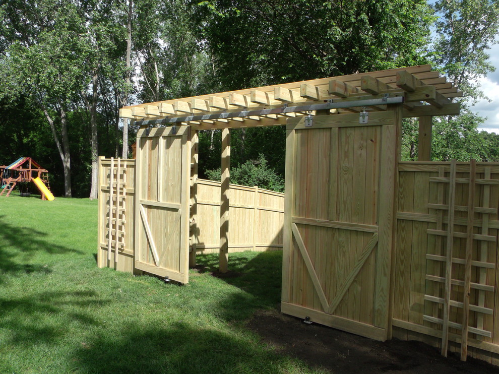 This is an example of a large arts and crafts side yard patio in Minneapolis with a pergola.
