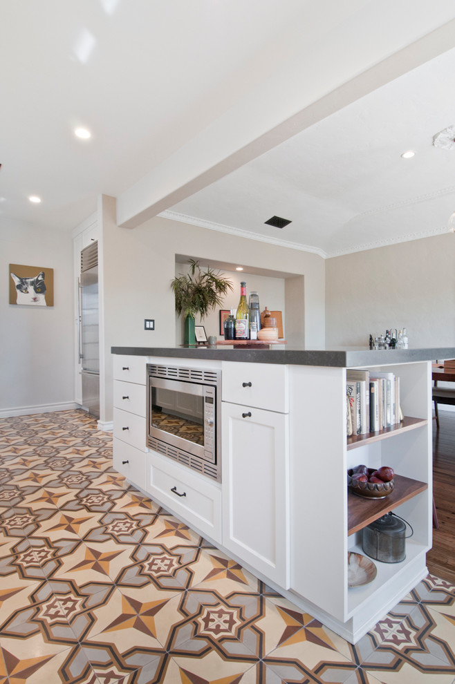 Mid-sized transitional galley eat-in kitchen in Los Angeles with an undermount sink, shaker cabinets, white cabinets, quartzite benchtops, white splashback, ceramic splashback, stainless steel appliances, cement tiles, with island and yellow floor.