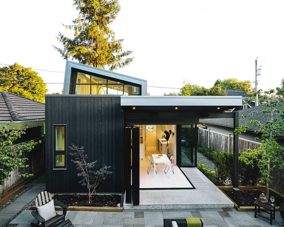 Стильный дизайн: одноэтажный, деревянный, черный частный загородный дом среднего размера в скандинавском стиле - последний тренд