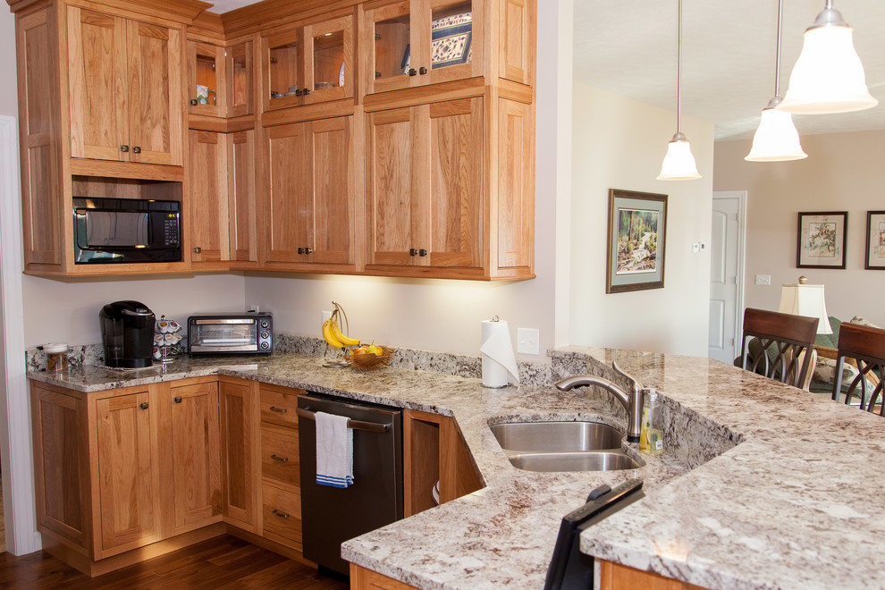 Inspiration for a mid-sized rustic u-shaped medium tone wood floor eat-in kitchen remodel with an undermount sink, shaker cabinets, light wood cabinets, granite countertops, stainless steel appliances and a peninsula