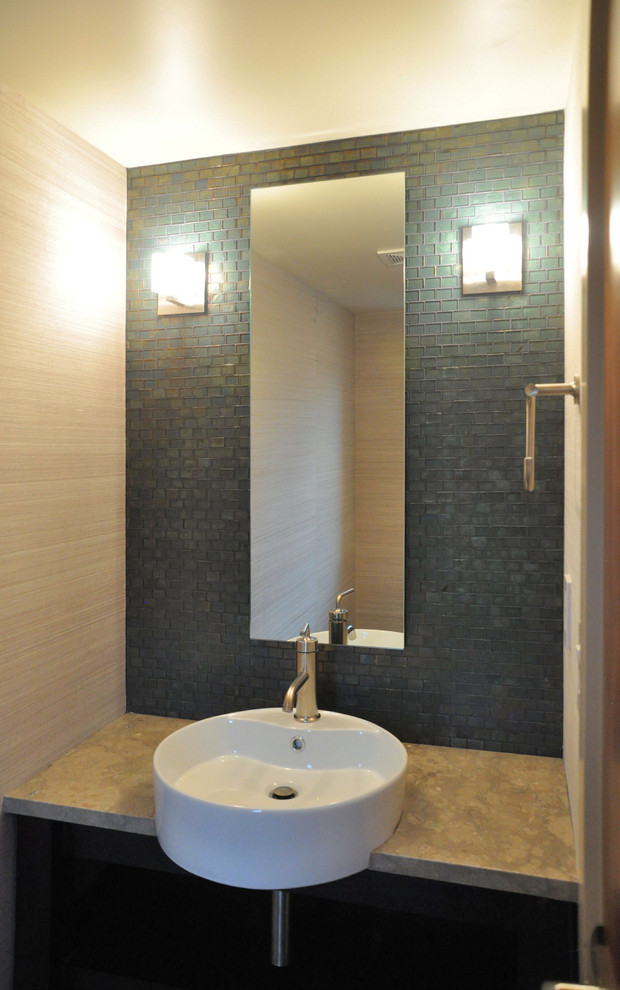 Photo of a mid-sized contemporary powder room in Seattle with a two-piece toilet, gray tile, mosaic tile, grey walls, a vessel sink, limestone benchtops and grey benchtops.