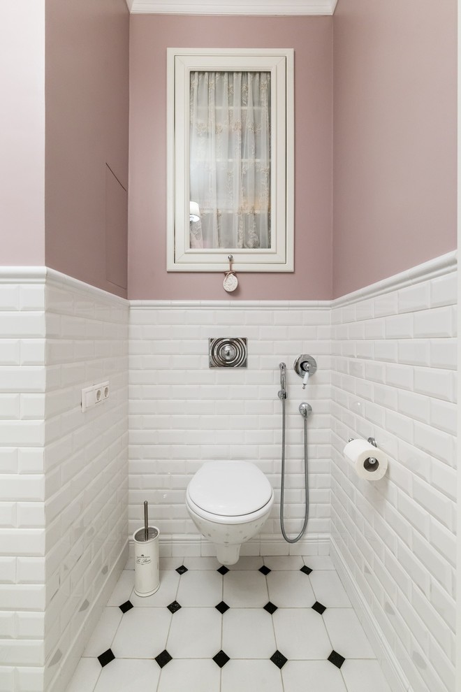 Traditional powder room in Moscow with a wall-mount toilet, white tile, subway tile, pink walls and multi-coloured floor.