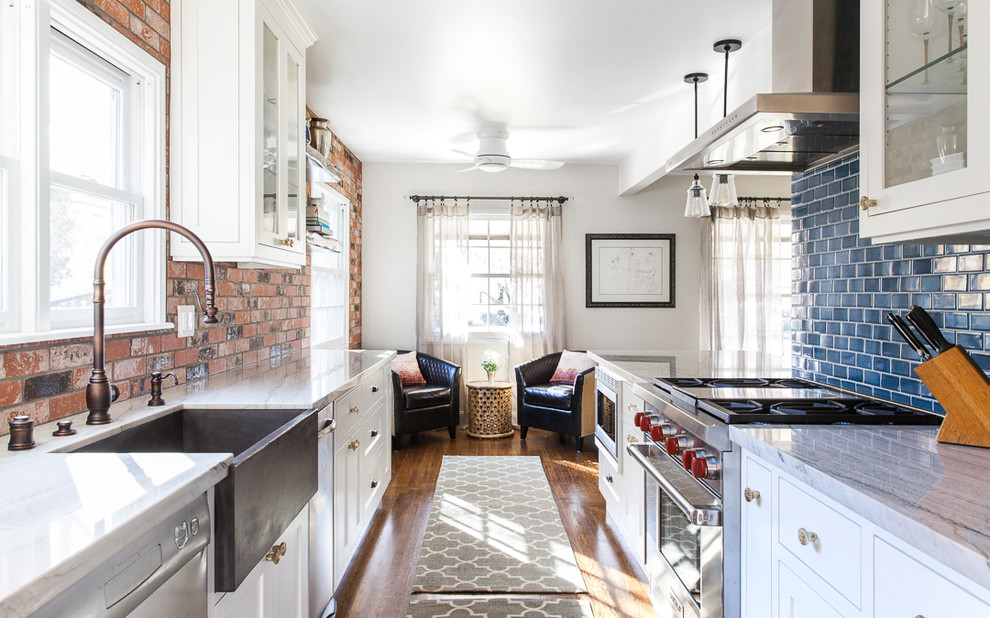 Design ideas for a mid-sized country galley eat-in kitchen in Sacramento with a farmhouse sink, shaker cabinets, white cabinets, quartzite benchtops, blue splashback, ceramic splashback, stainless steel appliances, medium hardwood floors, with island and brown floor.