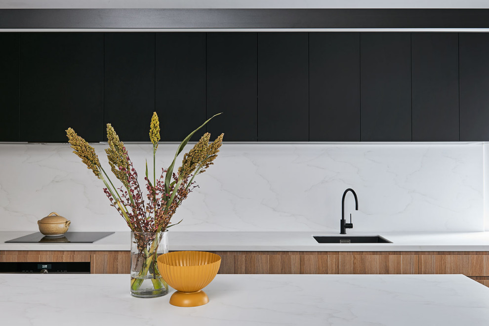Inspiration for a small contemporary l-shaped eat-in kitchen in Geelong with an undermount sink, light wood cabinets, quartz benchtops, white splashback, engineered quartz splashback, stainless steel appliances, concrete floors, with island, grey floor and white benchtop.