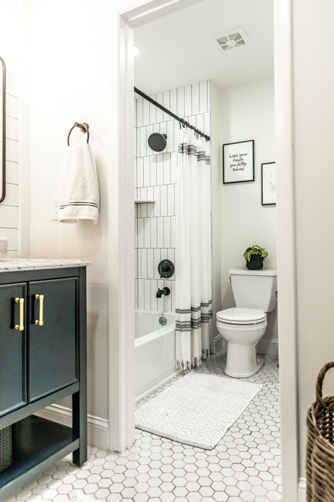 Photo of a small farmhouse ensuite bathroom in Baltimore with beaded cabinets, blue cabinets, an alcove bath, an alcove shower, a two-piece toilet, white tiles, ceramic tiles, white walls, a built-in sink, marble worktops, a shower curtain, white worktops, double sinks and a freestanding vanity unit.