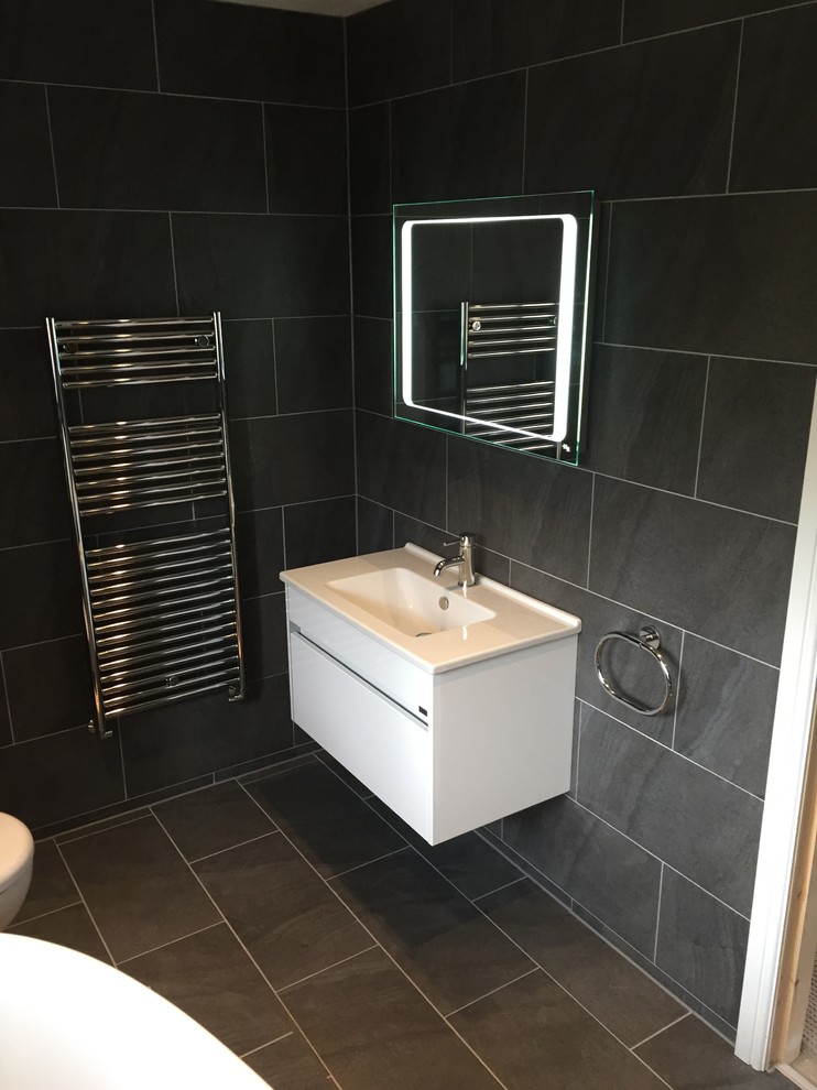 Mid-sized contemporary kids bathroom in Other with flat-panel cabinets, white cabinets, a freestanding tub, an open shower, a one-piece toilet, gray tile, porcelain tile, grey walls, porcelain floors and a wall-mount sink.