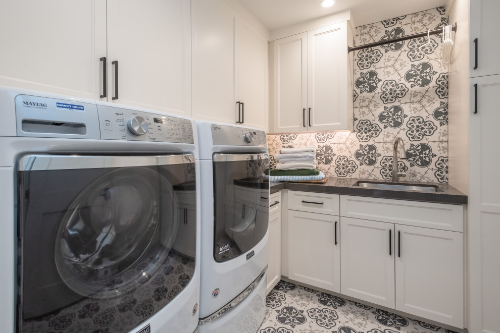 Inspiration for a mediterranean l-shaped dedicated laundry room in San Francisco with an undermount sink, recessed-panel cabinets, white cabinets, a side-by-side washer and dryer, multi-coloured floor, grey benchtop, quartzite benchtops, multi-coloured walls and ceramic floors.