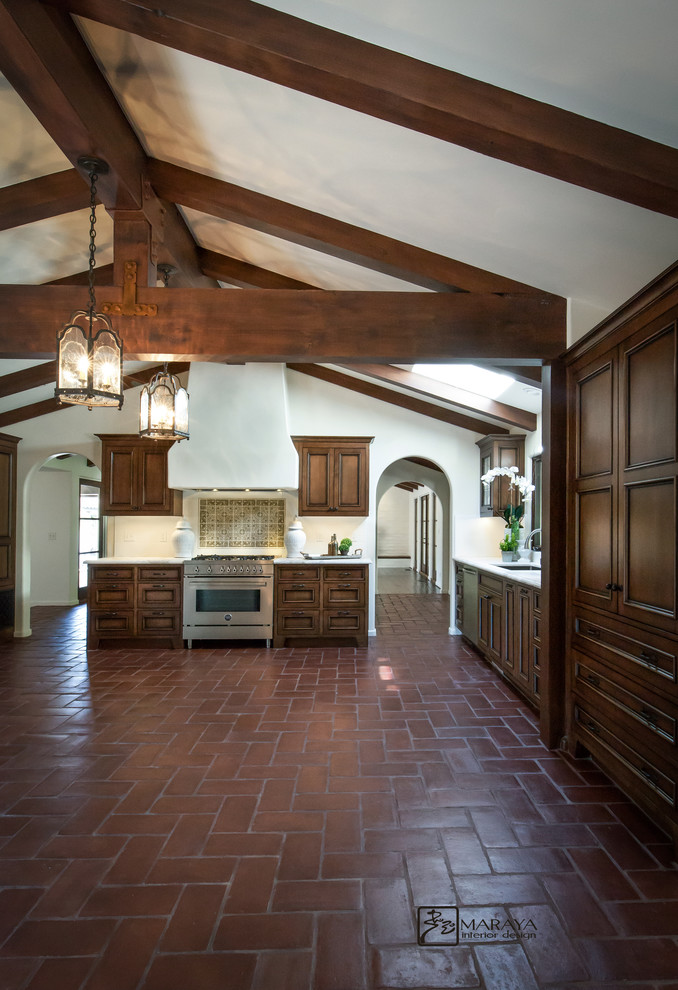 Large mediterranean u-shaped eat-in kitchen in Santa Barbara with an undermount sink, recessed-panel cabinets, distressed cabinets, marble benchtops, white splashback, subway tile splashback, stainless steel appliances, terra-cotta floors and no island.