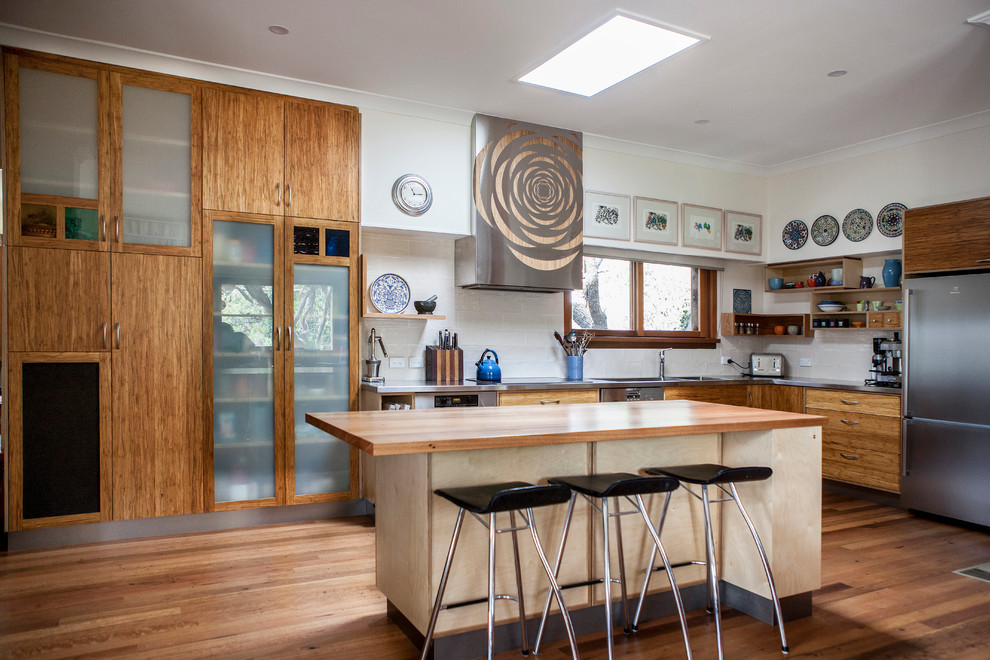 This is an example of a contemporary kitchen pantry in Canberra - Queanbeyan with a double-bowl sink, wood benchtops, yellow splashback, ceramic splashback, stainless steel appliances, medium hardwood floors and with island.