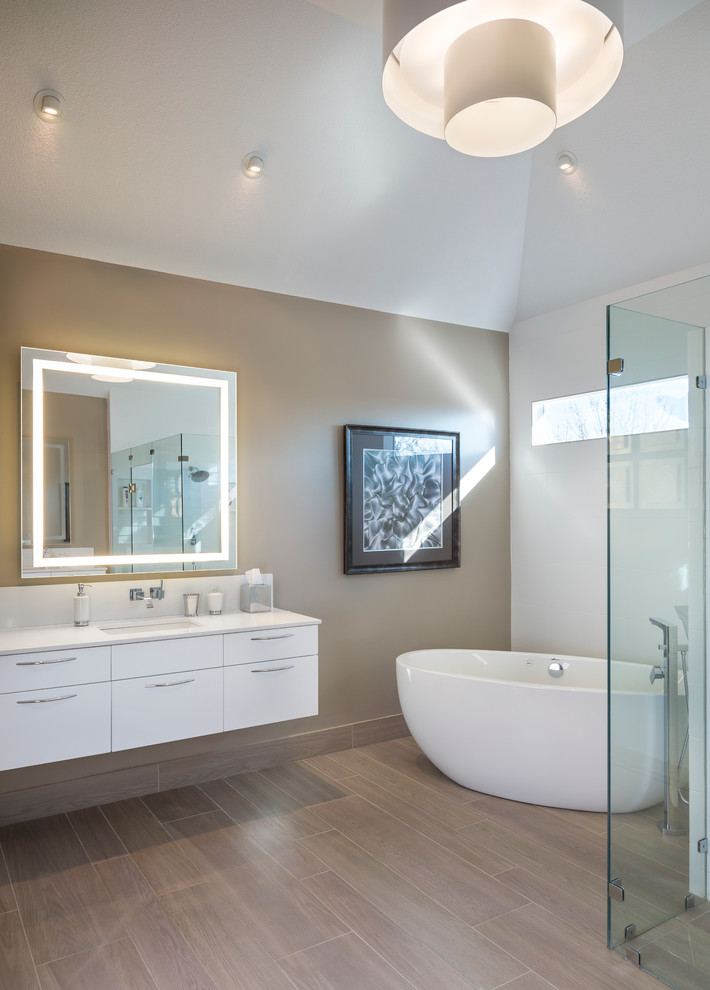 Large contemporary master bathroom in Kansas City with an undermount sink, flat-panel cabinets, white cabinets, engineered quartz benchtops, a freestanding tub, a curbless shower, a one-piece toilet, gray tile, ceramic tile, multi-coloured walls and ceramic floors.