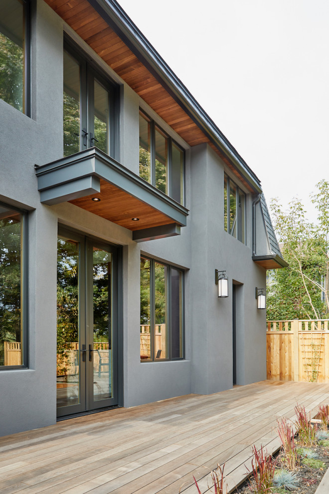 Aménagement d'une terrasse en bois arrière avec une extension de toiture.