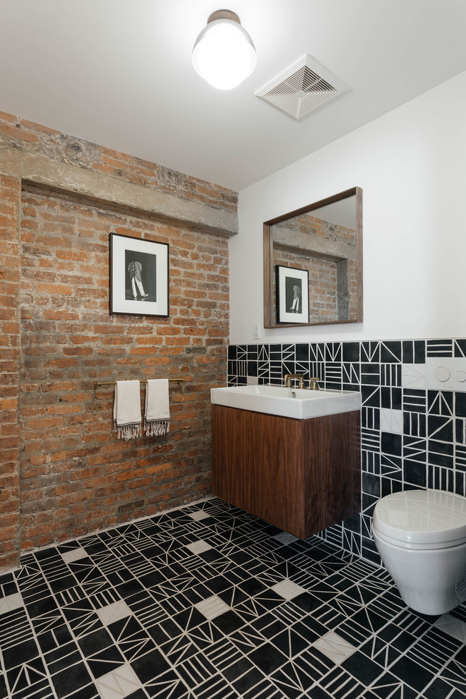 Contemporary powder room in New York with flat-panel cabinets, dark wood cabinets, a wall-mount toilet, black and white tile, white walls, a wall-mount sink, black floor, white benchtops and cement tiles.