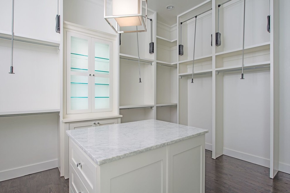 This is an example of a large contemporary gender-neutral walk-in wardrobe in Dallas with shaker cabinets, white cabinets and dark hardwood floors.