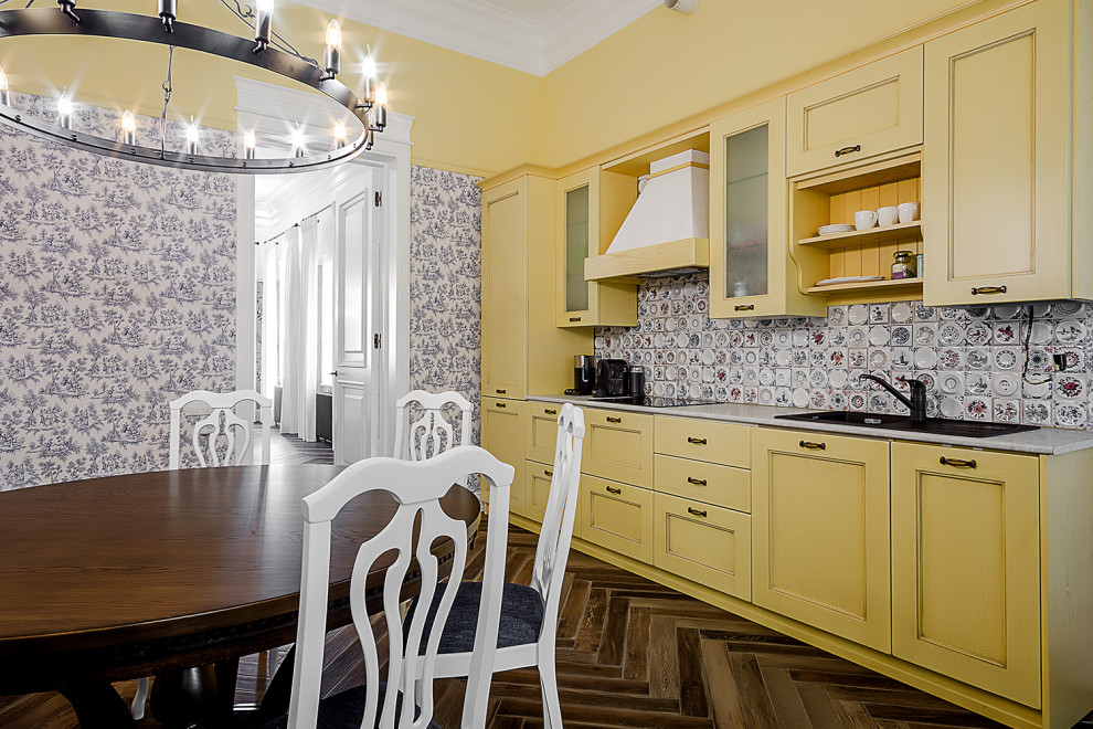 Ejemplo de cocina lineal vintage con fregadero encastrado, puertas de armario amarillas, salpicadero multicolor, suelo marrón y encimeras grises