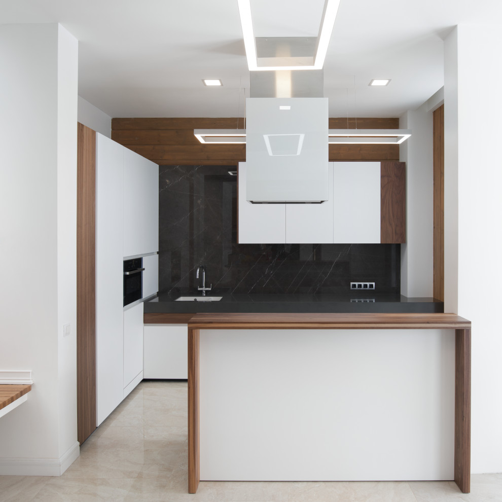 Design ideas for a mid-sized contemporary l-shaped eat-in kitchen in Moscow with a single-bowl sink, white cabinets, solid surface benchtops, black splashback, marble splashback, panelled appliances, with island and black benchtop.