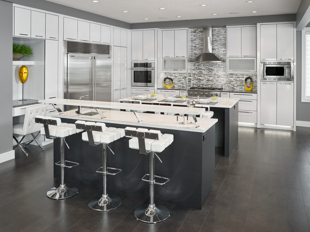 Inspiration for a large contemporary l-shaped eat-in kitchen in Edmonton with an undermount sink, flat-panel cabinets, white cabinets, quartz benchtops, multi-coloured splashback, mosaic tile splashback, stainless steel appliances and multiple islands.