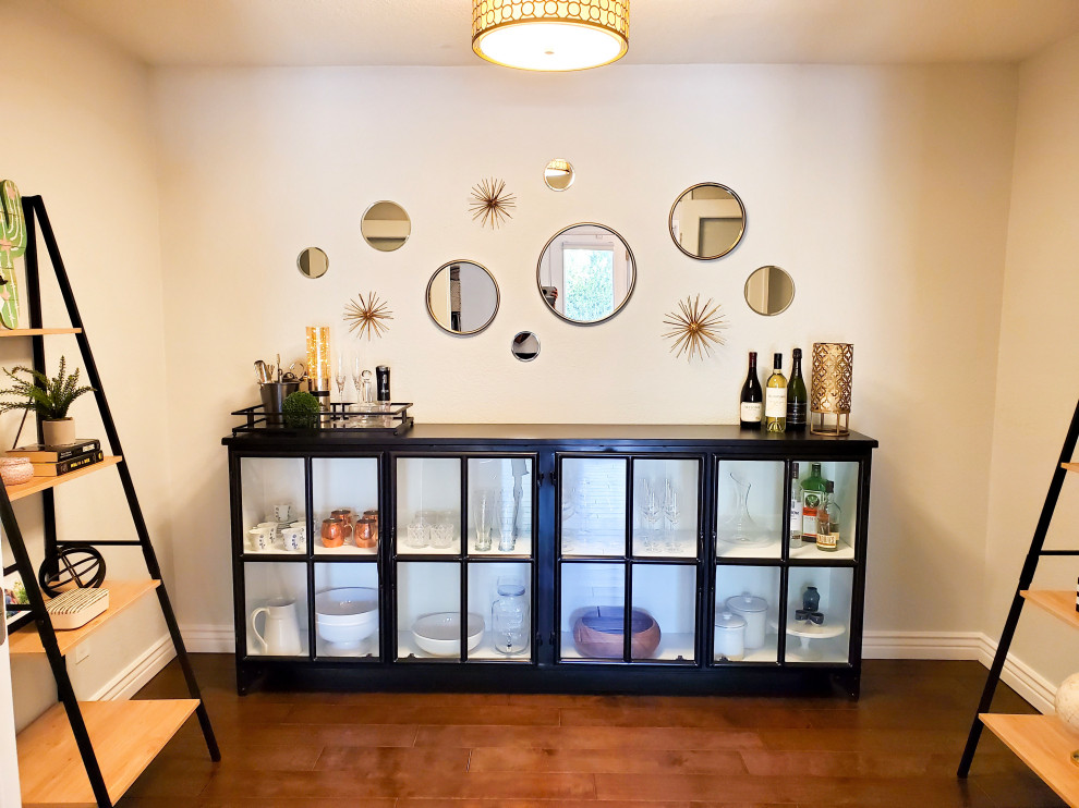 Small transitional u-shaped home bar in Phoenix with glass-front cabinets, black cabinets, dark hardwood floors, brown floor and black benchtop.