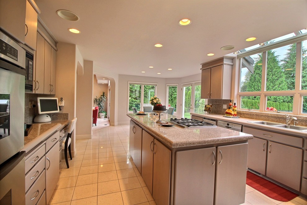 This is an example of a mid-sized transitional l-shaped eat-in kitchen in Seattle with flat-panel cabinets, stainless steel appliances, with island, beige floor and beige cabinets.