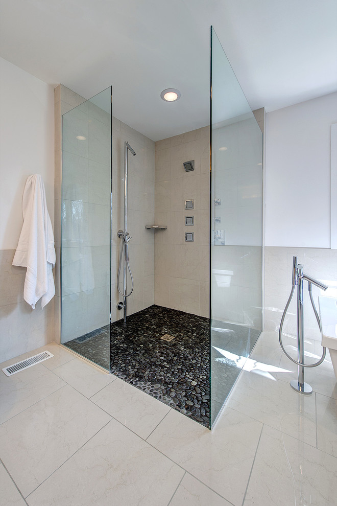 Large contemporary ensuite bathroom in St Louis with a built-in shower, a vessel sink, light wood cabinets, granite worktops, a freestanding bath, white tiles, porcelain tiles, white walls and pebble tile flooring.