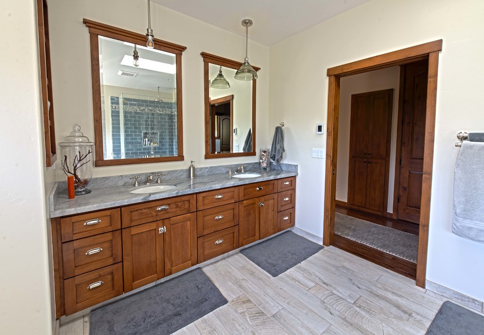 Photo of a large arts and crafts master bathroom in San Francisco with shaker cabinets, dark wood cabinets, an undermount tub, a corner shower, a one-piece toilet, blue tile, glass tile, white walls, travertine floors, an undermount sink, granite benchtops, grey floor, a hinged shower door and blue benchtops.