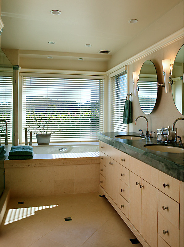 Mid-sized traditional master bathroom in San Francisco with flat-panel cabinets, beige cabinets, an undermount tub, an alcove shower, a one-piece toilet, beige tile, stone slab, beige walls, limestone floors, an undermount sink, marble benchtops, beige floor, a hinged shower door and green benchtops.