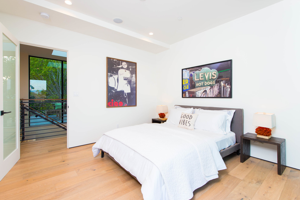 This is an example of a contemporary bedroom in Los Angeles with white walls, light hardwood floors and beige floor.