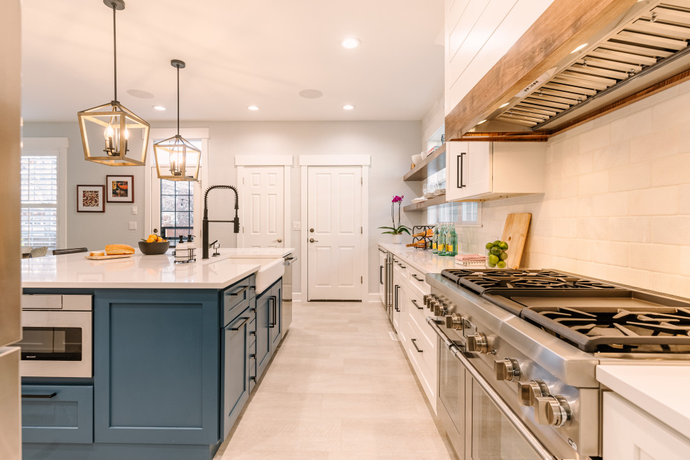 Inspiration for a large country l-shaped open plan kitchen in Denver with a single-bowl sink, shaker cabinets, blue cabinets, quartzite benchtops, white splashback, ceramic splashback, stainless steel appliances, vinyl floors, with island, beige floor and white benchtop.