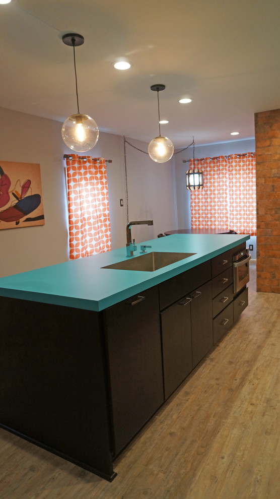 Photo of a mid-sized eclectic single-wall eat-in kitchen in Philadelphia with an undermount sink, flat-panel cabinets, dark wood cabinets, laminate benchtops, multi-coloured splashback, ceramic splashback, stainless steel appliances, vinyl floors, with island and beige floor.