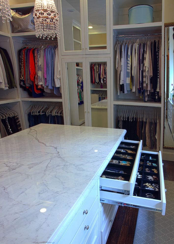 This is an example of a large traditional women's walk-in wardrobe in Dallas with recessed-panel cabinets, white cabinets and medium hardwood floors.