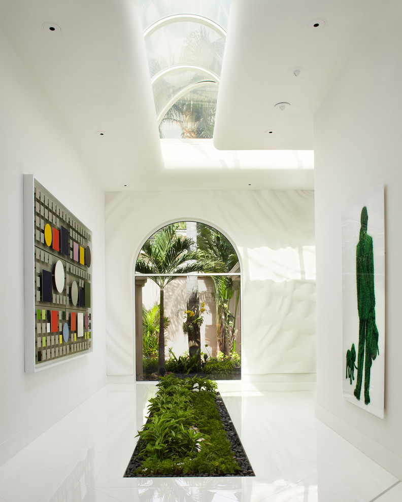 Contemporary hallway in Miami with white walls and white floor.
