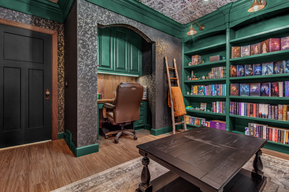 Modelo de despacho vintage pequeño con biblioteca, suelo de madera en tonos medios, escritorio empotrado, suelo marrón y papel pintado